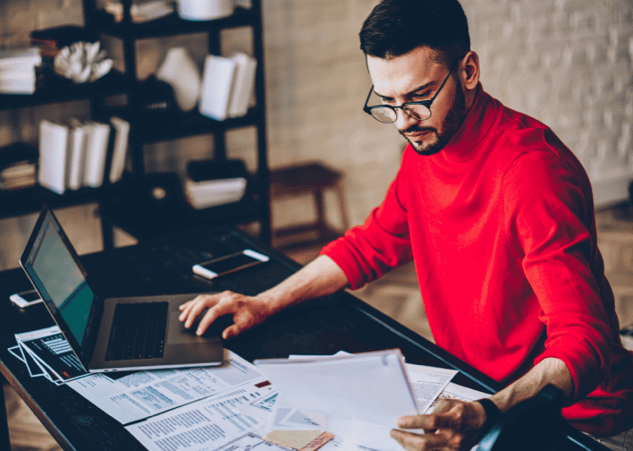 An image of a person sitting at a desk with papers working