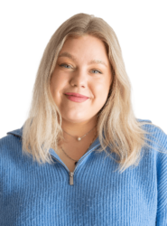 A photo of Elza who has medium-length blonde hair and is wearing a light blue jumper, smiling.