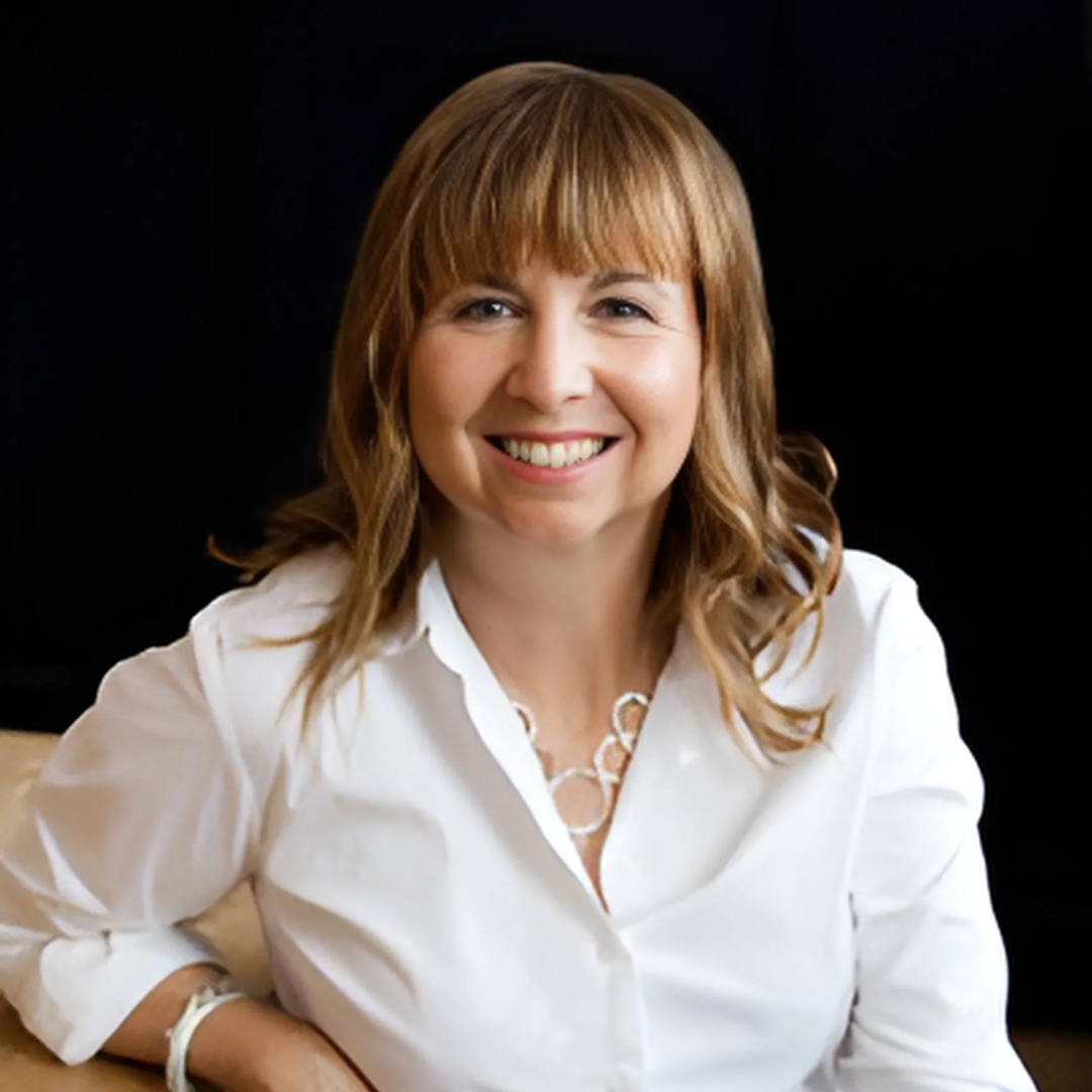 Guest Speaker, Sarah Petherbridge, is wearing a white shirt and seated at a table.